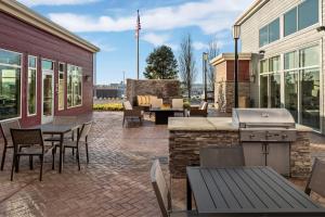 um pátio com comodidades para churrascos, mesas e cadeiras em Residence Inn by Marriott Portland Clackamas em Clackamas