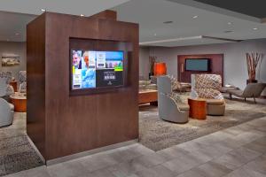 a hotel lobby with a flat screen tv on a wall at Courtyard by Marriott Stuart in Stuart