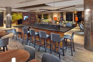 a bar in a hotel lobby with chairs and tables at Courtyard by Marriott Stuart in Stuart