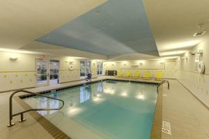 une grande piscine avec des chaises jaunes dans un bâtiment dans l'établissement Fairfield Inn & Suites by Marriott Meridian, à Meridian