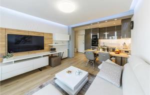 a living room with a white couch and a kitchen at Cozy Apartment In Pula With Wifi in Pula