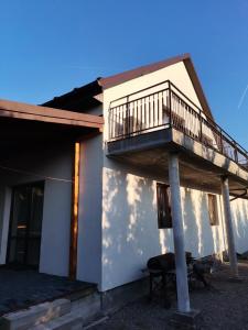 a house with a balcony on the side of it at Apartament u Wioli in Okleśna