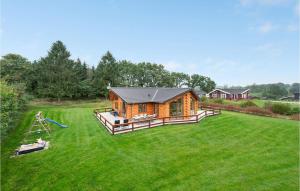 un gran patio con una cabaña de madera y un parque infantil en Awesome Home In Ejstrupholm With Sauna, en Ejstrup