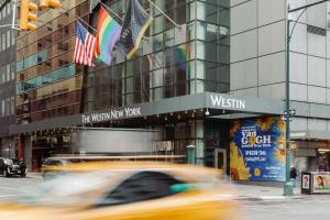 a car driving down a street in front of a building at The Westin New York at Times Square in New York