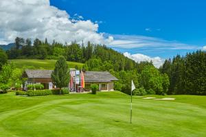 a golf course with a house and a putting green at Urlaub "im Marktl" in Goldegg