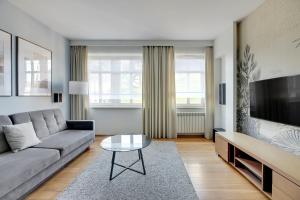 een woonkamer met een bank en een tv bij Willa Morska Deluxe by Grand Apartments in Sopot