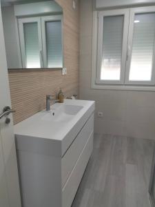 Baño blanco con lavabo y espejo en Os Carballás-Vilaboa-Pazos nº54, en Vilaboa
