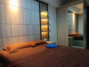Klandasan Kecil的住宿－Borneo Bay City Apartment Balikpapan，一间卧室配有一张带大型木制床头板的床