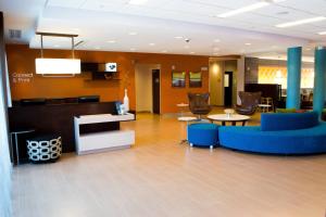 a lobby with a blue couch and tables and chairs at Fairfield Inn & Suites by Marriott Fort Walton Beach-West Destin in Fort Walton Beach