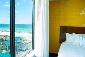 a bedroom with a bed and a view of the beach at Fairfield Inn & Suites by Marriott Fort Walton Beach-West Destin in Fort Walton Beach