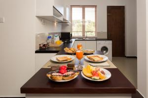 - une table avec des assiettes de nourriture dans la cuisine dans l'établissement Niwahas Apartments Kottawa, à Pannipitiya