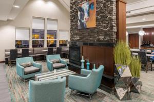 a lobby with blue chairs and a fireplace at Residence Inn by Marriott Harrisonburg in Harrisonburg