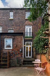 利物浦的住宿－FLATZY - Iconic Beatles and Liverpool Culture Home，前面有桌子的砖砌建筑