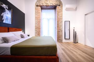 a bedroom with a large bed and a brick wall at Interno Barocco in Naples