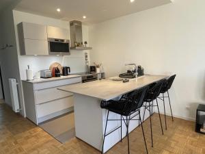 a kitchen with a counter and two bar stools at Très bel appartement T3 centre ville, commerces et gare in Rambouillet