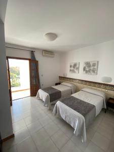 a bedroom with two beds and a large window at Hotel Sim&oacute;n in Moj&aacute;car