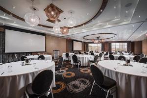 a conference room with tables and chairs and a projection screen at Delta Hotels by Marriott Waterloo in Waterloo