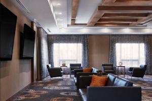 a waiting room with couches and chairs and windows at Delta Hotels by Marriott Waterloo in Waterloo