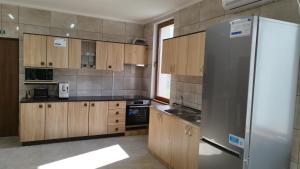 una cucina con mobili in legno e un frigorifero in acciaio inossidabile di Pensiunea Florilor Satu Mare a Satu Mare