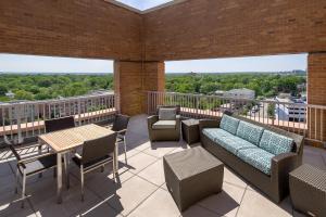 a balcony with a couch and tables and chairs at Residence Inn by Marriott Arlington Ballston in Arlington