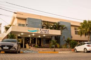 a hotel with cars parked in front of a building at Costa do Rio Hotel in Petrolina