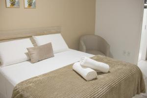 a bedroom with a bed with two towels on it at Costa do Rio Hotel in Petrolina