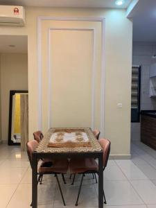 CheeAyu@ Putrajaya IOI Resort في بوتراجايا: طاولة وكراسي في غرفة مع طاولة وباب