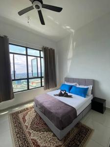 CheeAyu@ Putrajaya IOI Resort في بوتراجايا: غرفة نوم مع سرير ومروحة سقف