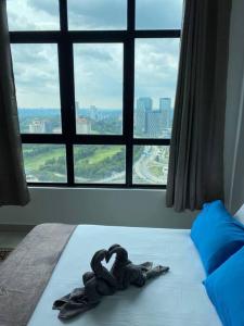 a pair of gloves laying on a bed in front of a window at CheeAyu@ Putrajaya IOI Resort in Putrajaya