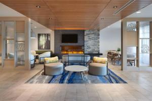vestíbulo con chimenea, mesa y sillas en Fairfield by Marriott Inn & Suites Orillia en Orillia