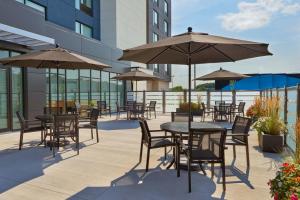 patio ze stołami, krzesłami i parasolami w obiekcie Fairfield by Marriott Inn & Suites Orillia w mieście Orillia