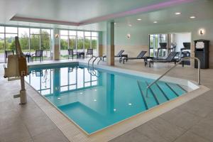 a swimming pool in a hotel with chairs and tables at Fairfield by Marriott Inn & Suites Orillia in Orillia