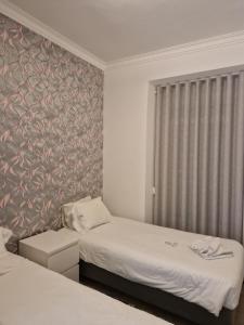 a hotel room with two beds and a window at Zuni Guest House in Lisbon