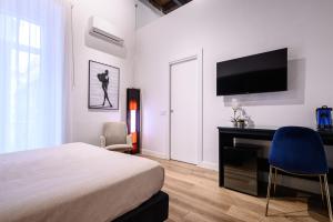 a bedroom with a bed and a desk and a television at Interno Barocco in Naples