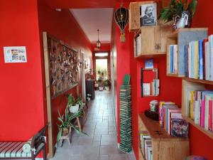 a hallway with red walls and bookshelves at Art Rooms Joyful People in Alberobello