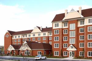 a large red brick building with a car parked in front at Residence Inn by Marriott Toronto Markham in Markham