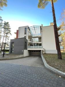 a large white building with a balcony on top of it at Apartament Morze Sztuki, Jantar in Jantar