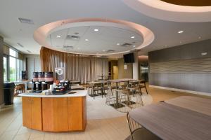 a restaurant with tables and stools in a room at SpringHill Suites Grand Forks in Grand Forks