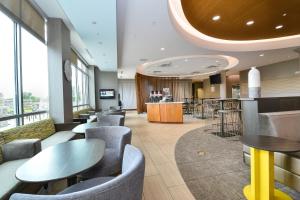 a lobby with tables and chairs and a bar at SpringHill Suites Grand Forks in Grand Forks