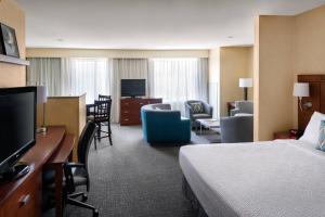 a hotel room with a bed and a living room at Courtyard by Marriott Sacramento Cal Expo in Sacramento