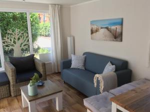 a living room with a blue couch and a table at Sunnychalet in Beekbergen