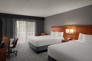 a hotel room with two beds and a window at Courtyard by Marriott Portland Beaverton in Beaverton