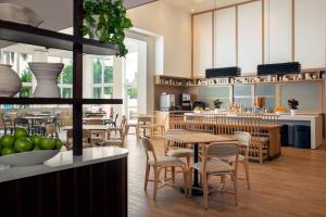 a restaurant with tables and chairs and a kitchen at Residence Inn by Marriott Miami Aventura Mall in Aventura