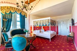 a bedroom with a bed and a table and chairs at Hotel Burg Trendelburg in Trendelburg