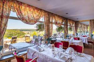 a restaurant with tables and chairs and a large window at Hotel Burg Trendelburg in Trendelburg