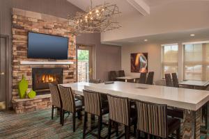 een eetkamer met een tafel en stoelen en een open haard bij Residence Inn Frederick in Frederick