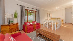 a living room with red furniture and a table at Main 38 in Struisbaai