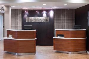 a lobby with two reception desks in a building at Courtyard by Marriott Pensacola in Pensacola