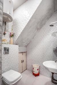 a white bathroom with a sink and a toilet at Homlee-Heritage 2-Bed Room Apt near Pragati Maidan in New Delhi