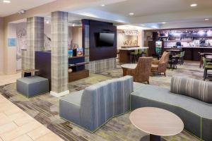 a lobby with a couch and tables and a bar at Courtyard by Marriott Pensacola in Pensacola